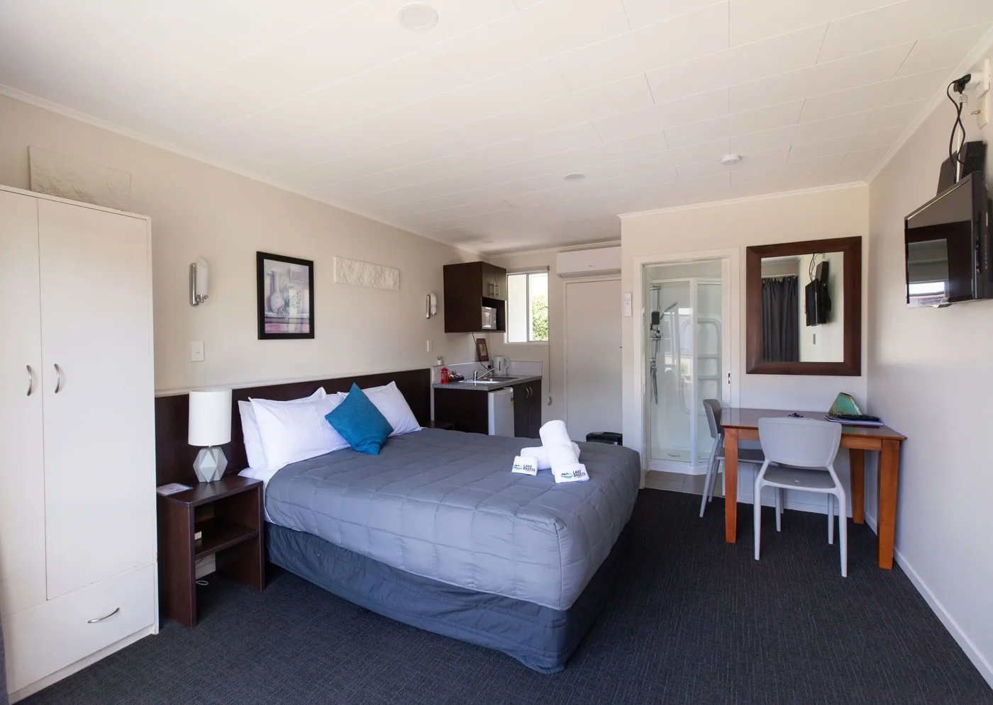 Queen Studio bed and dining area at Lake Breeze Motel